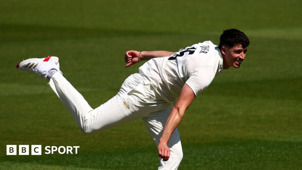 Matt Fisher bowling for Surrey in his follow-through