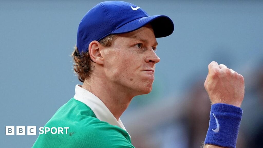 Jannik Sinner clenches his fist in celebration during his French Open match against Novak Djokovic