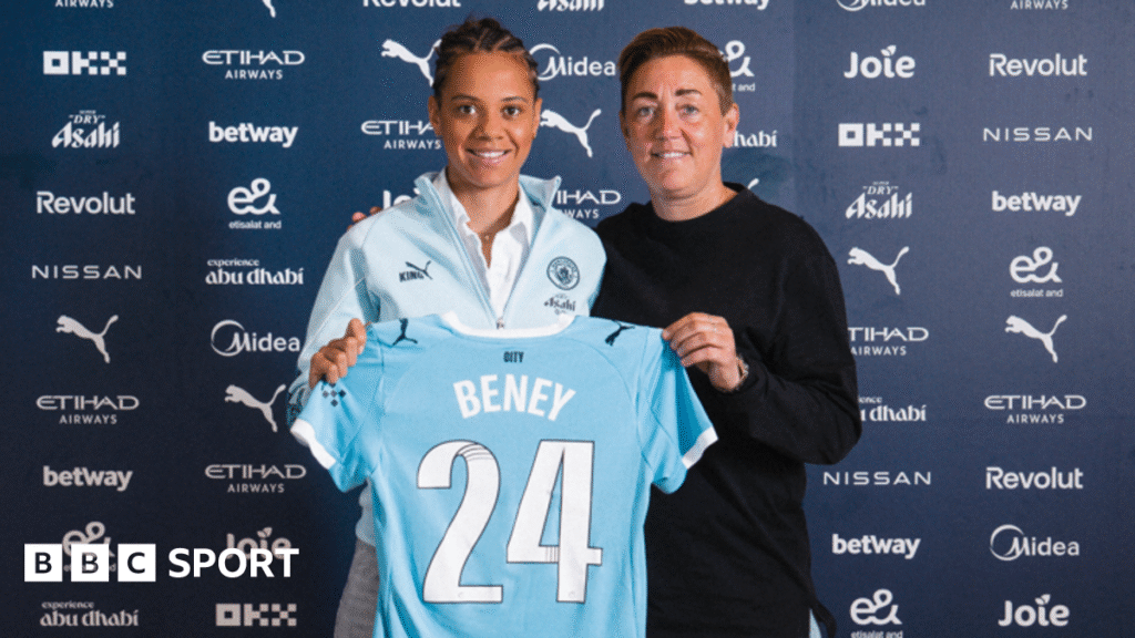 Iman Beney poses with a Manchester City shirt which has her name on
