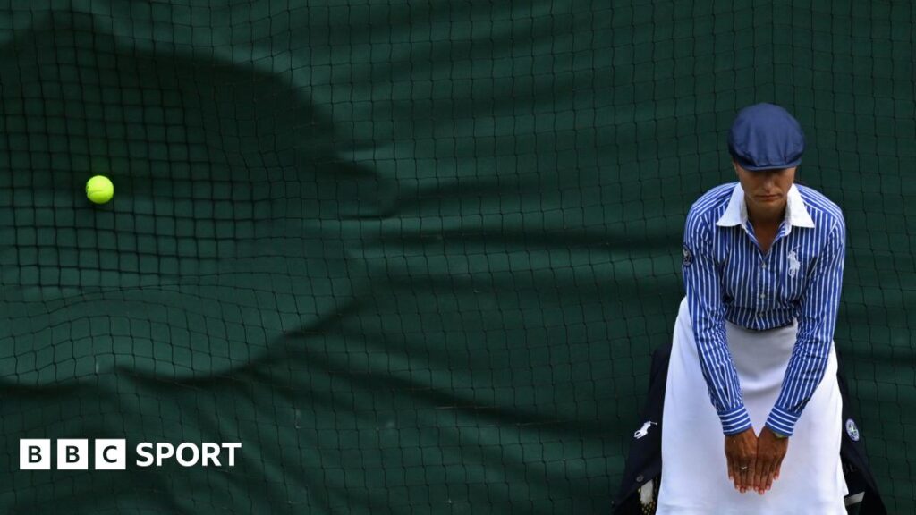 Wimbledon line judge leans forward to watch the line