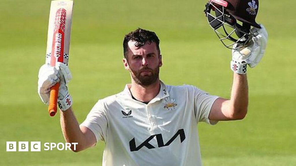 Dom Sibley raises his bat upon reaching a century for Surrey against Durham