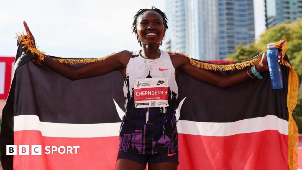 Ruth Chepngetich holds up a Kenyan flag after winning the Chicago Marathon