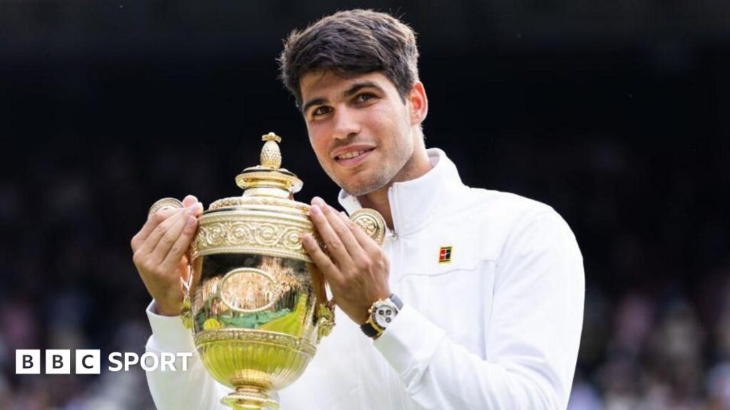 Carlos Alcaraz holds up the Wimbledon men's singles trophy after winning the 2024 final