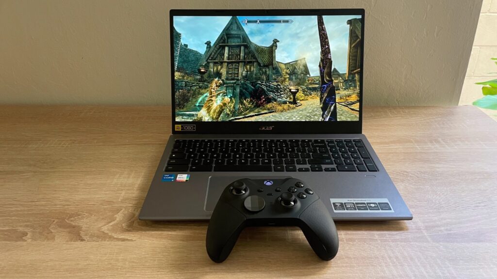 The Steam beta running on a Chromebook. The laptop is atop a wooden desk with a black Xbox controller sat on the front edge.