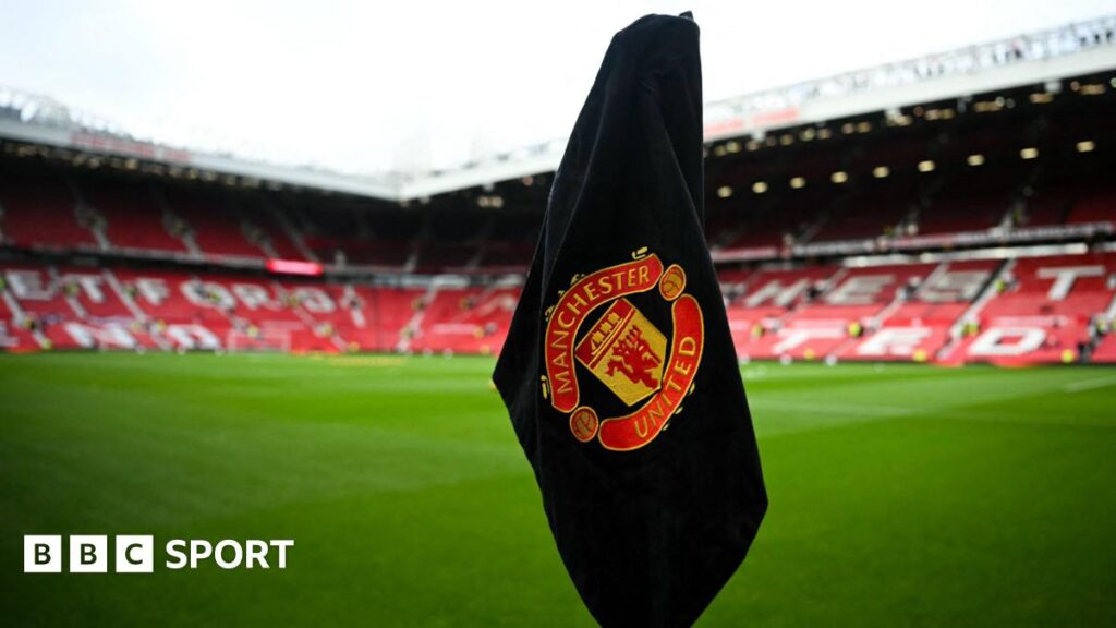The Manchester United logo on a black corner flag at Old Trafford