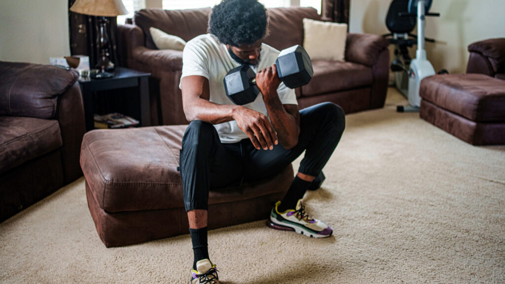 A man doing bicep curls on sofa