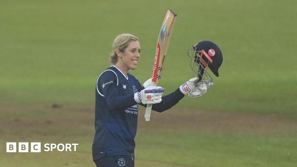 Georgia Adams raises her bat to acknowledge her century for Hampshire