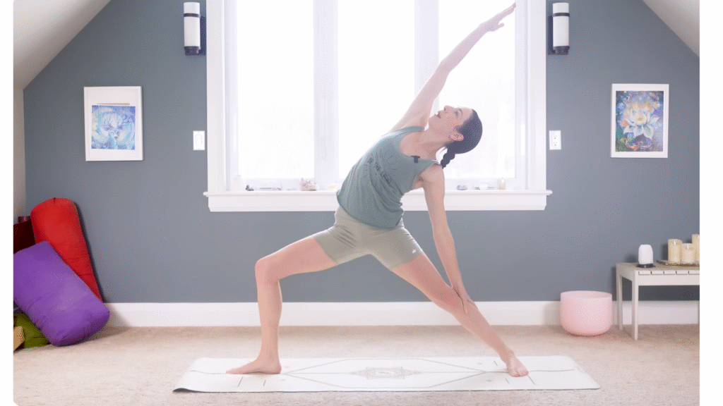 15-Minute Morning Yoga for the Full-Body Stretch You Need Woman in Reverse Warrior facing the long side of a mat and reaching her right arm alongside her head