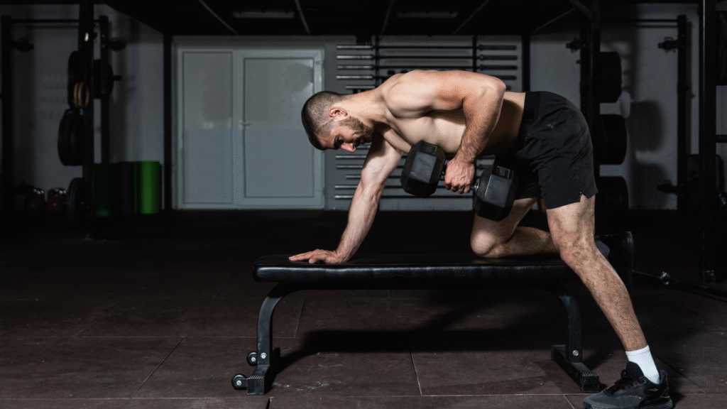 A man performing a bench supported dumbbell row at the gym