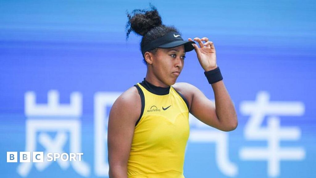 Naomi Osaka looking glum with her hand on her hat