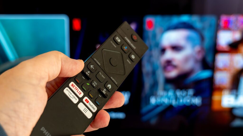 Netflix on a Philips remote control pointing at the TV