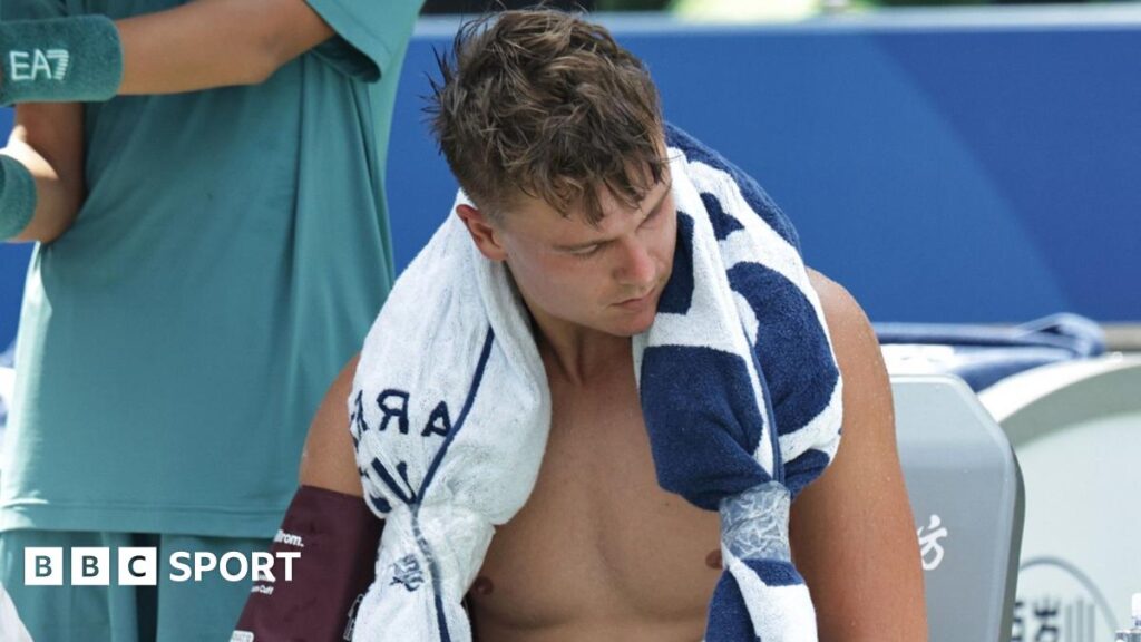 Holger Rune has his blood pressure taken as he sits with an ice towel over his shoulders at the Shanghai Masters
