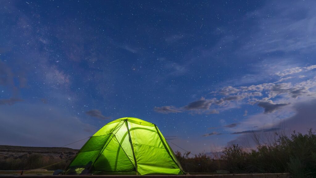 A bright green Northface Stormbreak 2 Tent beneath a starry sky in Chaco Canyon