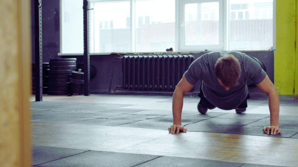 Bored With Your Core Workouts? Here’s What You Need. Guy in a gym struggling to a do a core workout