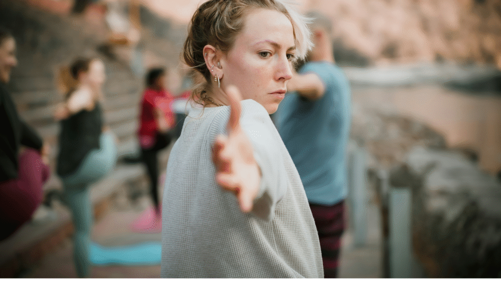 I Started Teaching Yoga When I Was 20. It Was Not What I Expected. Woman yoga teacher leading a yoga class at age 20