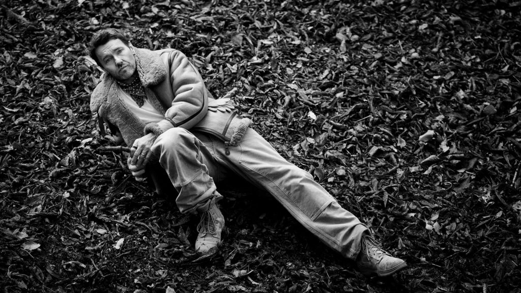 Joel Edgerton Talks ‘Train Dreams,’ Nature, and Finding Peace in the Wild Joel wears a T-shirt by Merz B. Schwanen from Clutch Cafe London; vintage Air Force Jacket, Carhartt pants, neck scarf, and vintage boots, his own.