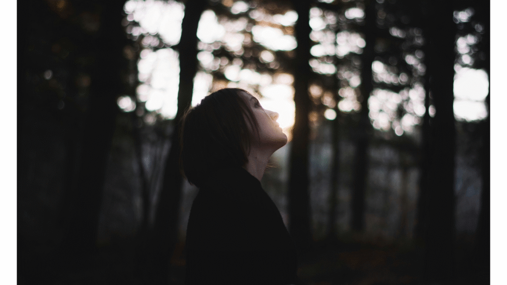 Woman standing outside just before dusk in autumn thinking about her weekly horoscope for November 2-8, 2025